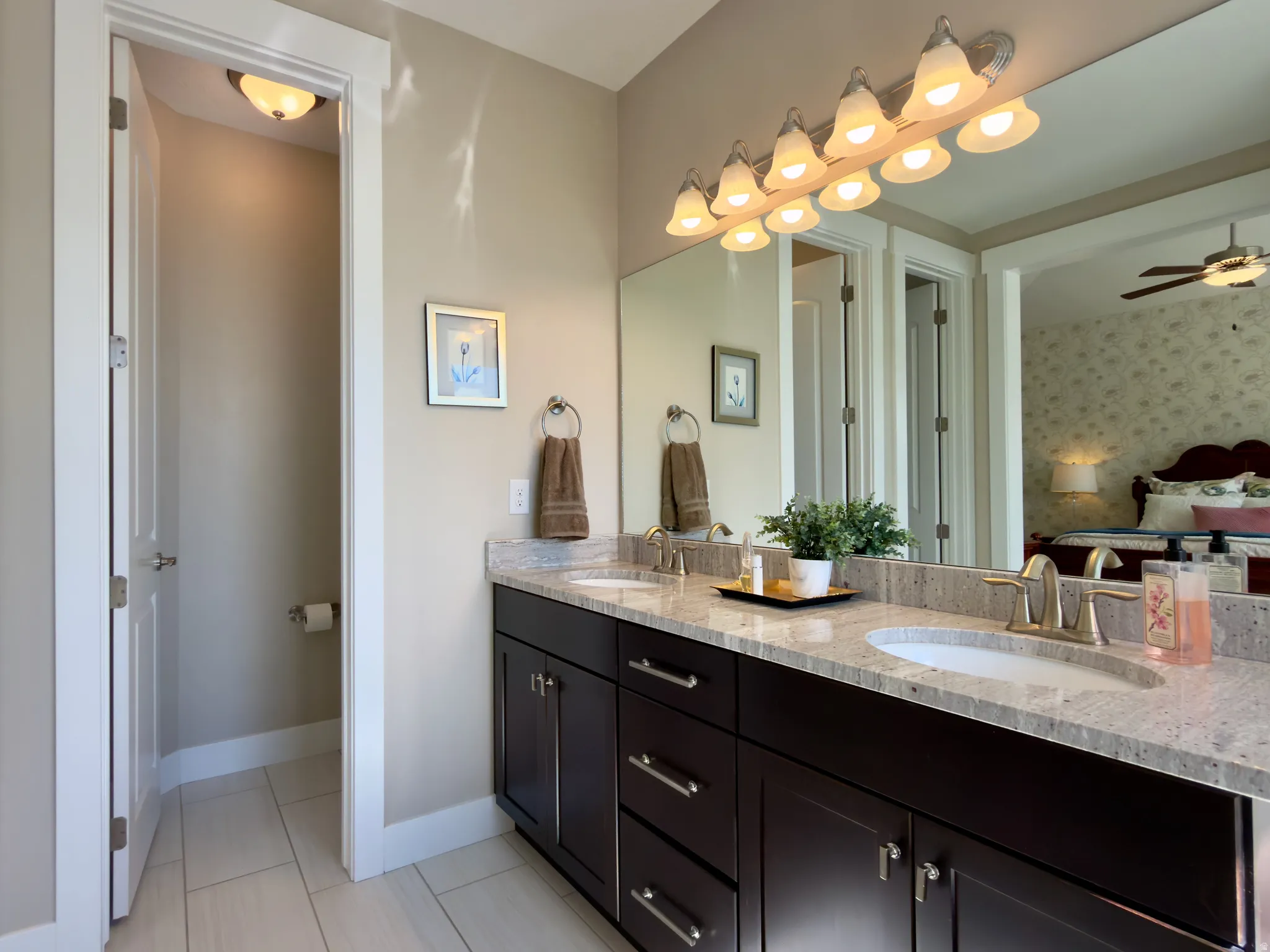 Bathroom featuring double vanity, a ceiling fan, and light tile patterned floors