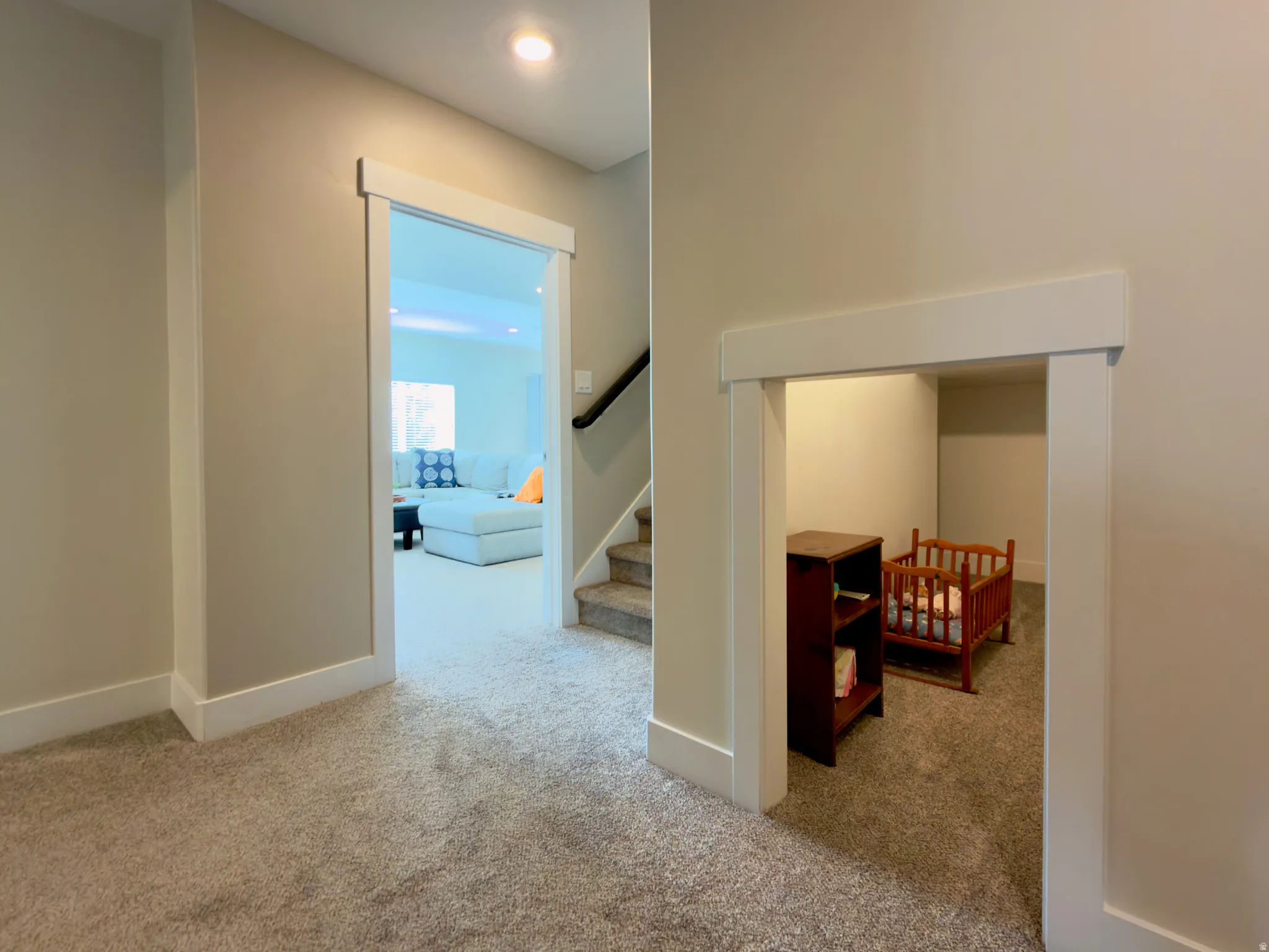 Hallway featuring light carpet