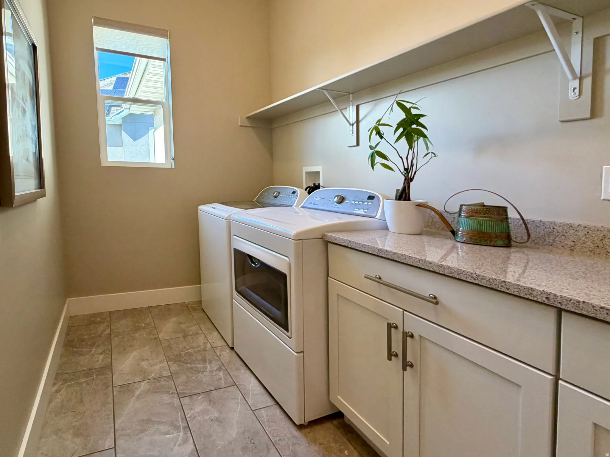 Laundry room featuring independent washer and dryer and cabinet space