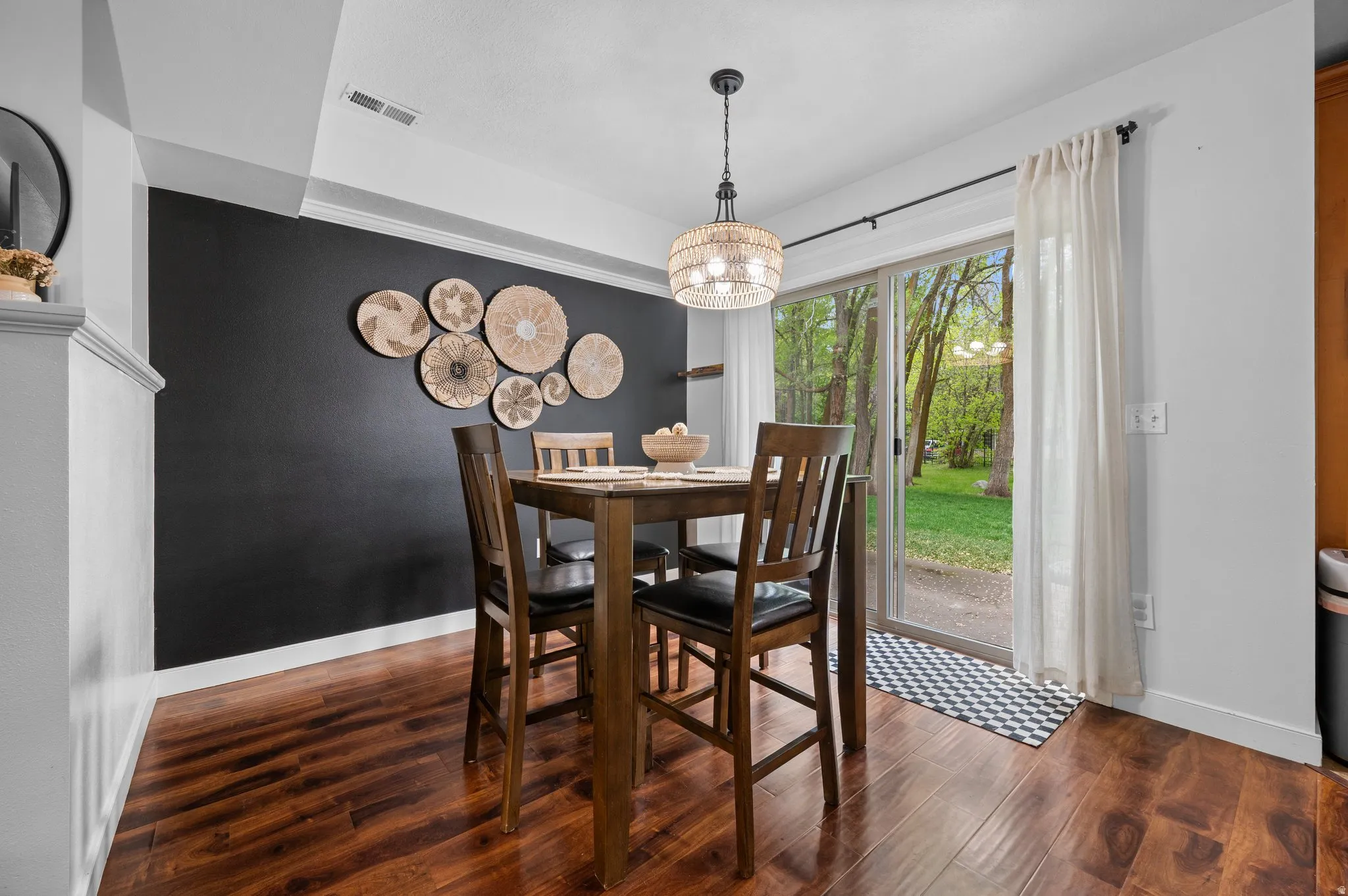 Dining room with wood finished floors and suspended lighting