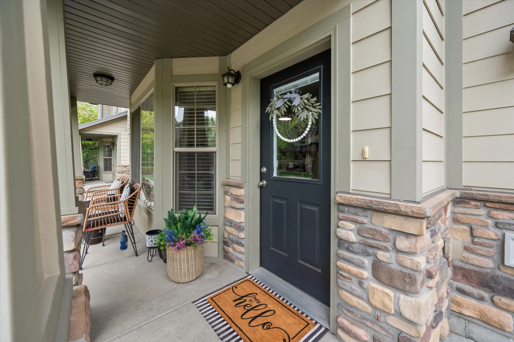 Property entrance featuring a porch and stone