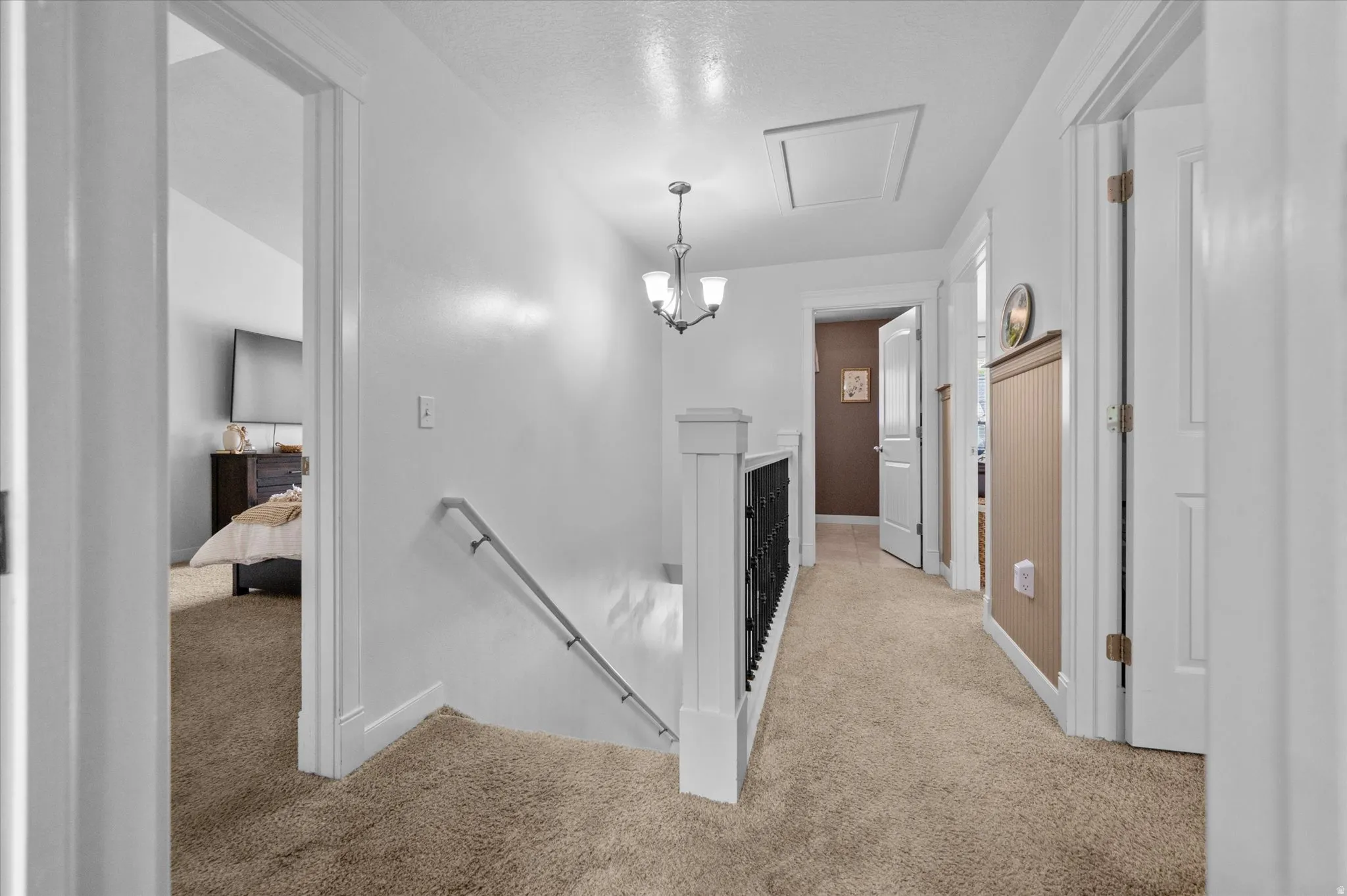 Hallway with an upstairs landing and light carpet