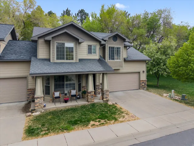 Craftsman inspired home with stone siding, covered porch, driveway,