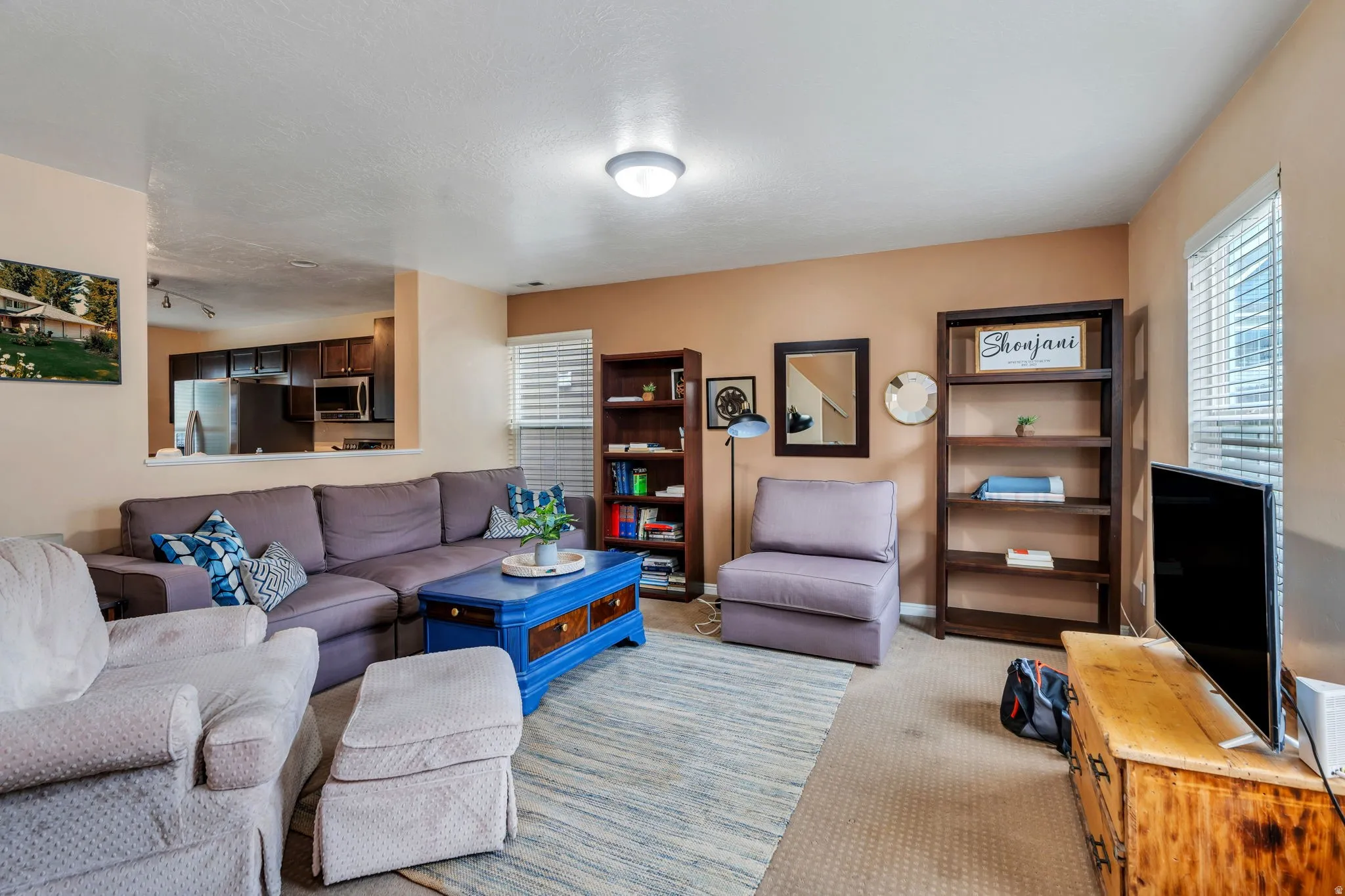Living area featuring light colored carpet and baseboards