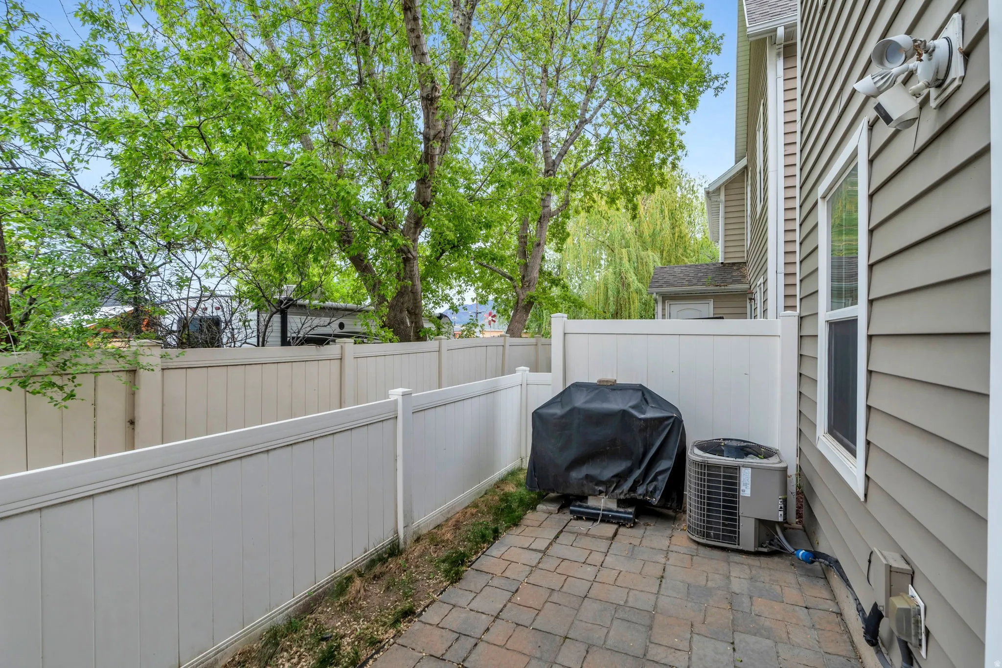Fenced backyard with a patio and grilling area