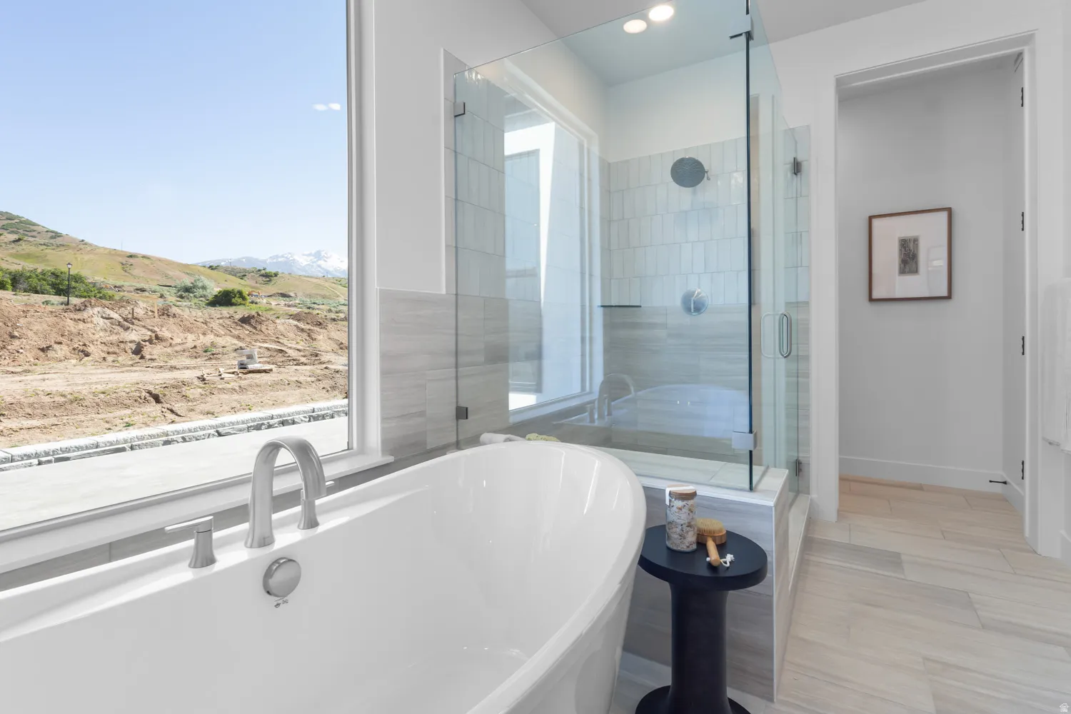Full bathroom featuring a shower stall, a freestanding tub, and a mountain view