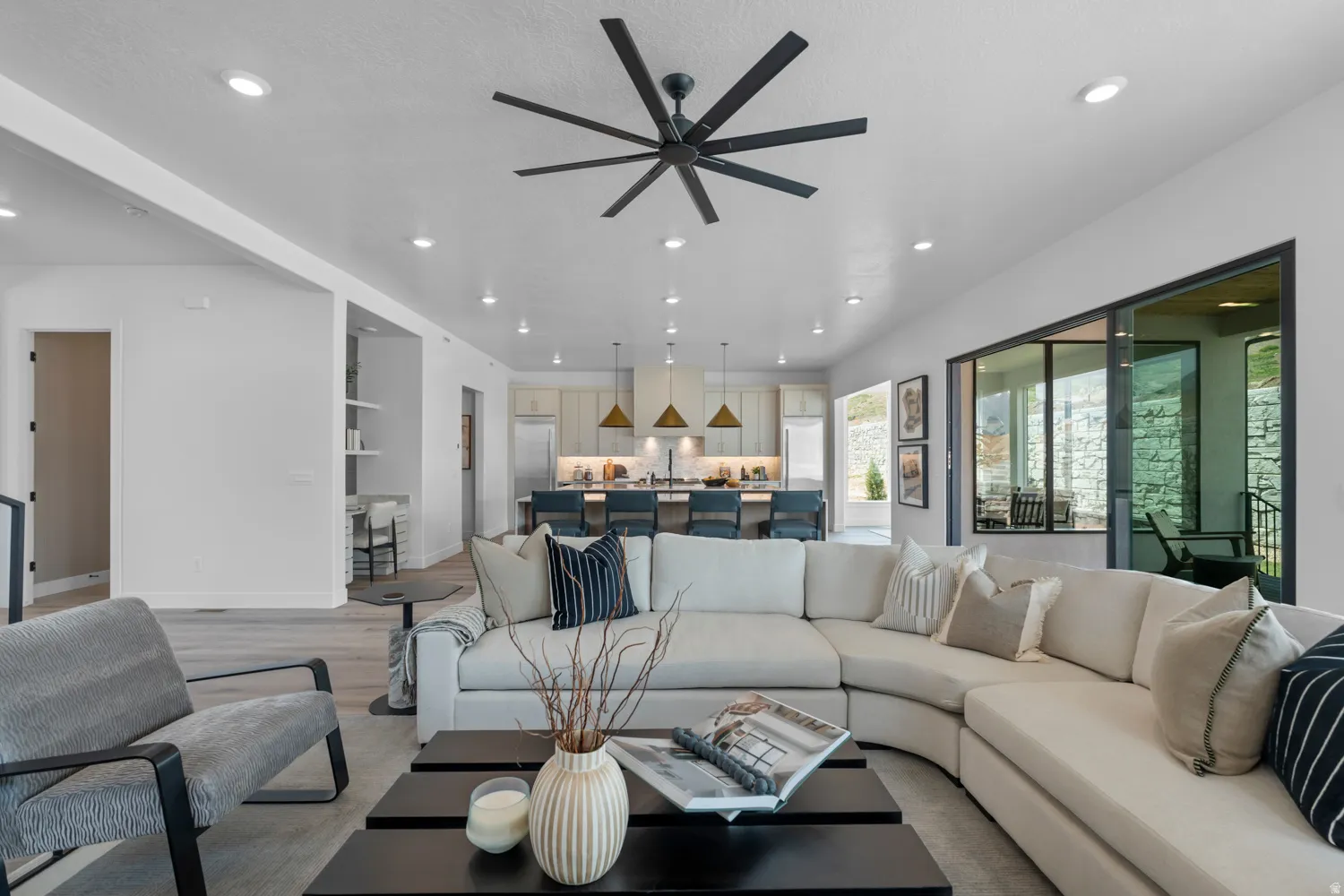 Living area with light wood finished floors, recessed lighting, and a ceiling fan
