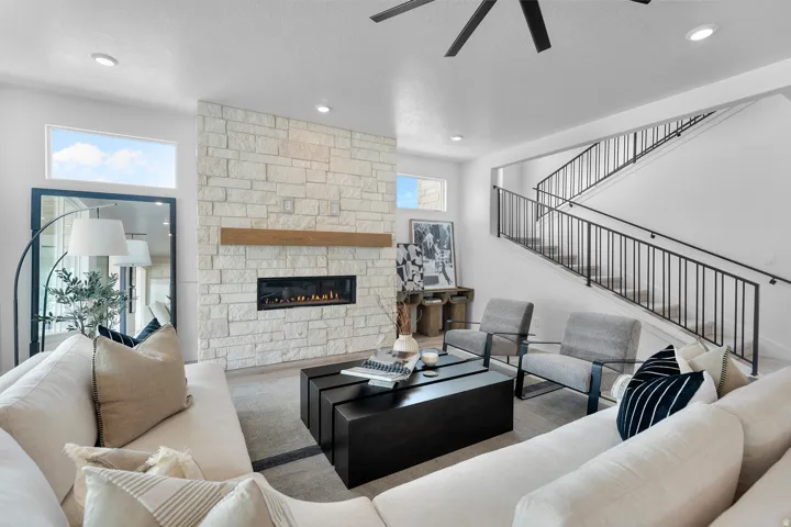Living room featuring a fireplace, a ceiling fan, and recessed lighting