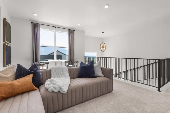 Carpeted living area featuring hanging lights
