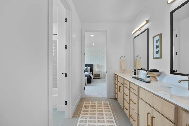 Bathroom featuring double vanity, light tile patterned floors, ensuite bath, and bathing tub / shower combination
