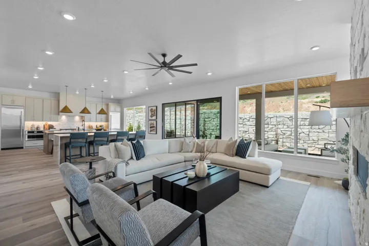 Living room featuring ceiling fan, light wood-type flooring, a stone fireplace, and recessed lighting