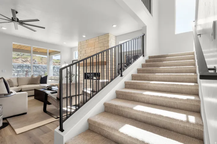 Stairway featuring healthy amount of natural light, wood finished floors, ceiling fan, and recessed lighting