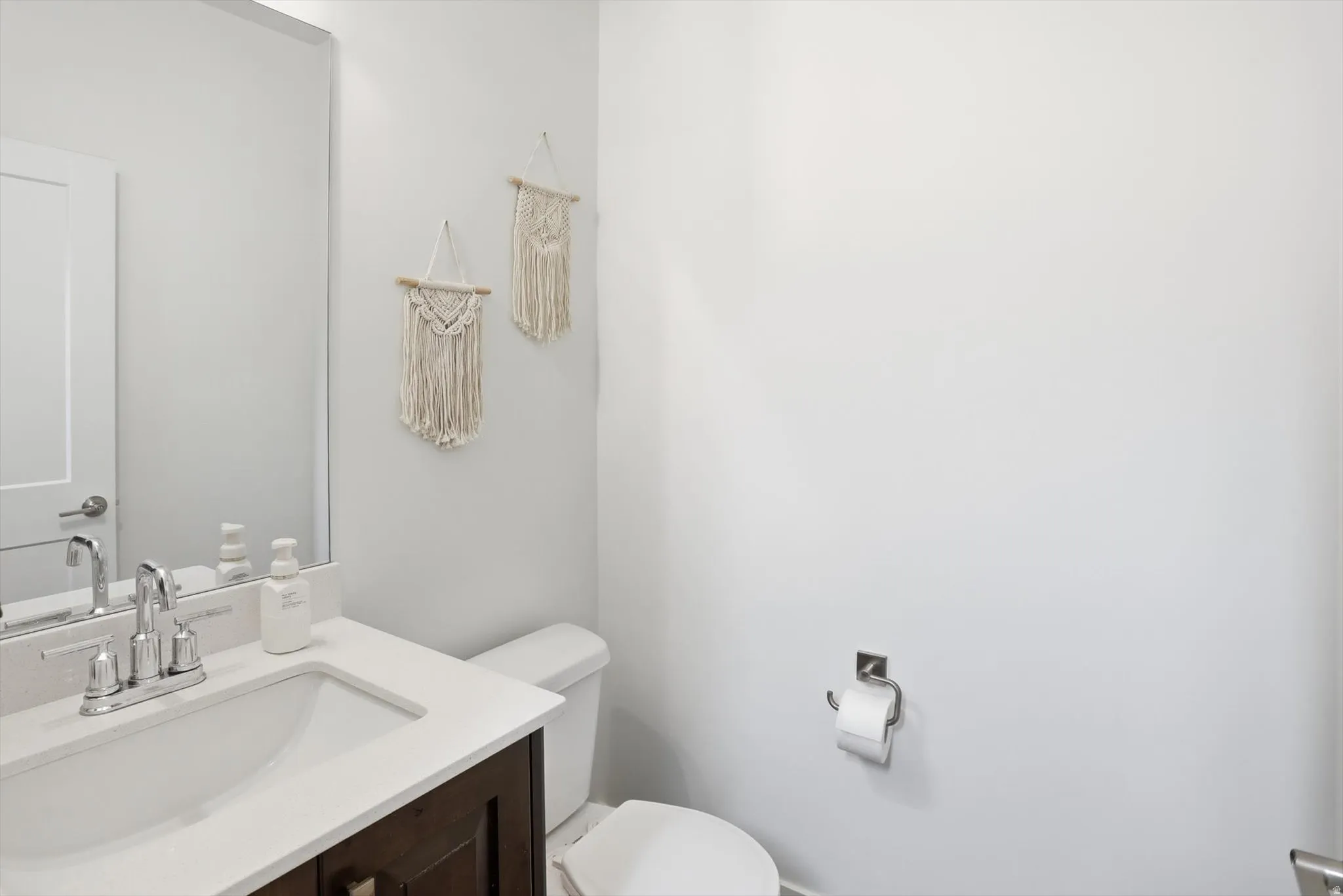 Half bathroom featuring vanity and toilet