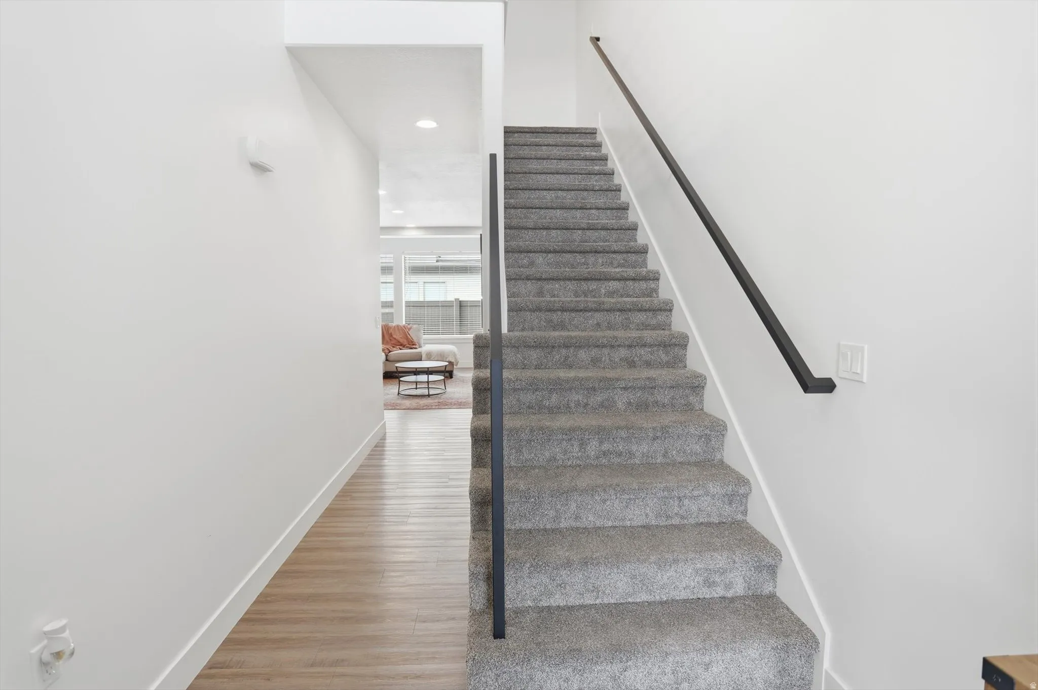 Stairway with wood finished floors and recessed lighting