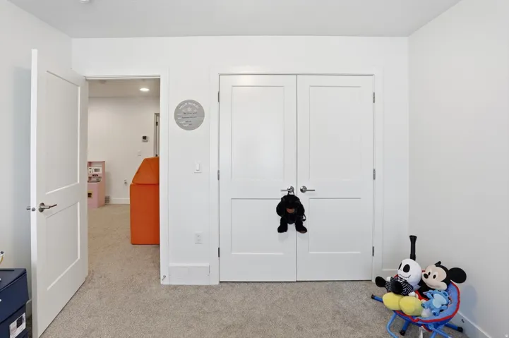 Unfurnished bedroom with light carpet and a closet