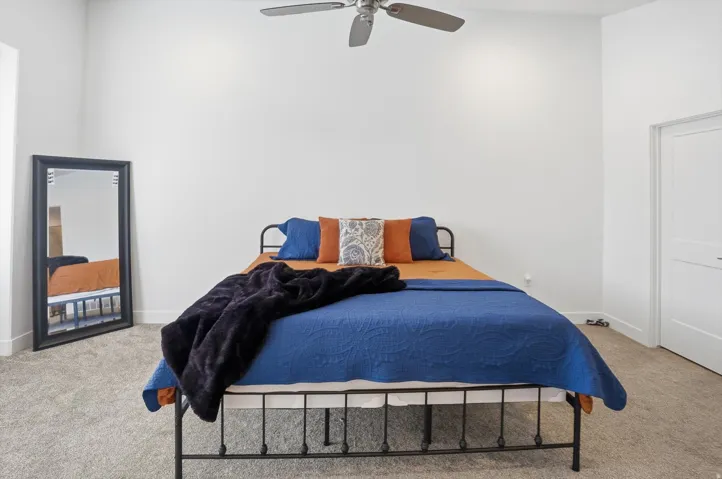 Bedroom featuring light carpet and a ceiling fan