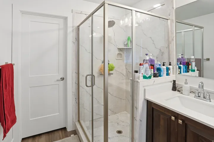 Full bath with vanity and a marble finish shower