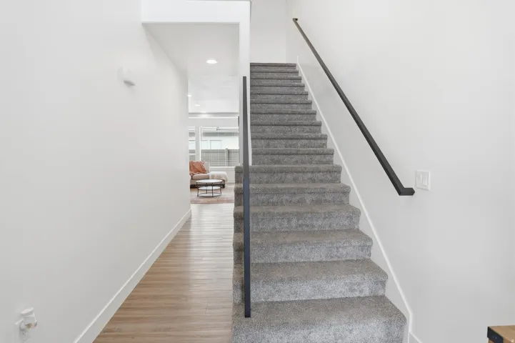 Stairway with wood finished floors and recessed lighting