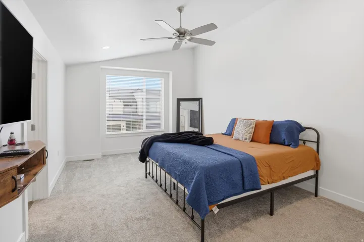 Bedroom with vaulted ceiling, a ceiling fan, light carpet, and recessed lighting