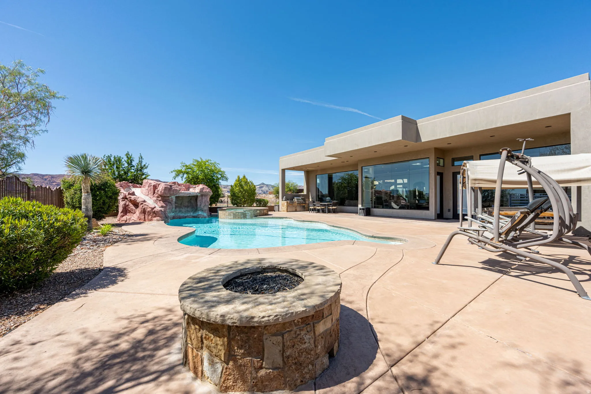 Integrated pool / hot tub featuring a patio area and an outdoor fire pit