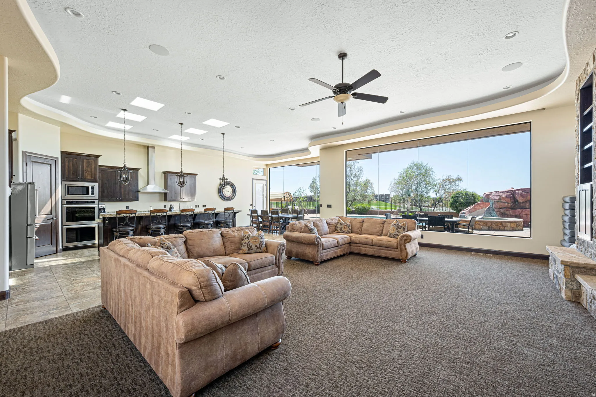 Living area featuring carpet floors, ceiling fan, and a textured ceiling