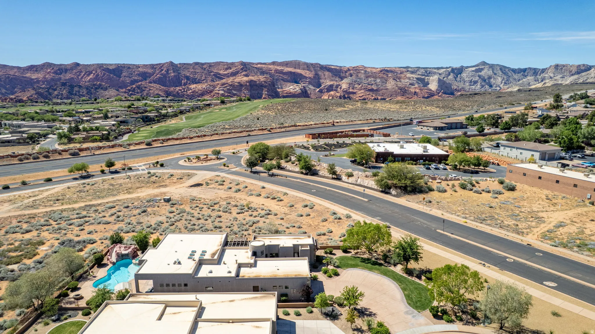 Aerial view of property and surrounding area with a mountain backdrop