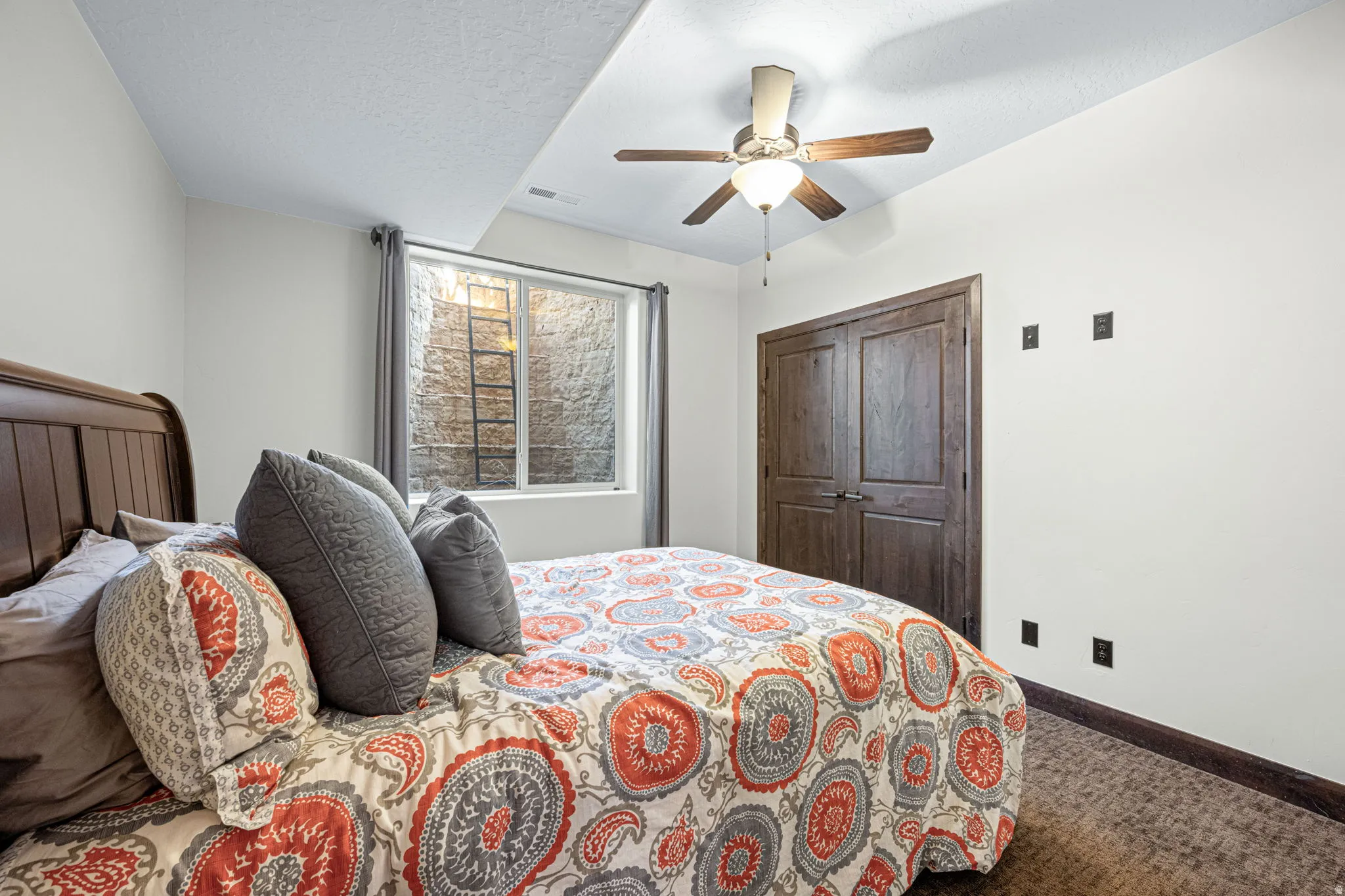 Carpeted bedroom featuring a ceiling fan, a closet, and a textured ceiling