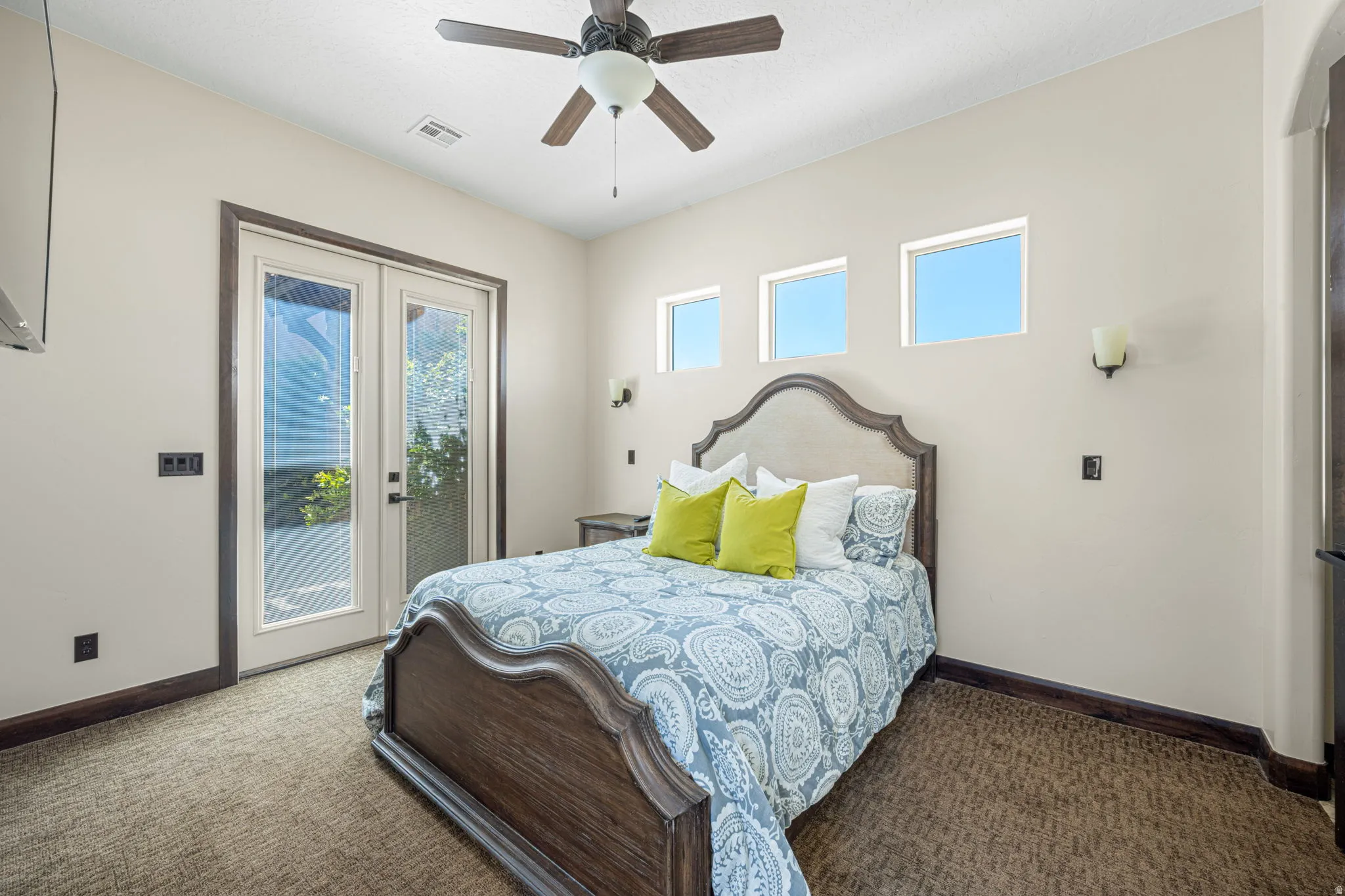 Bedroom featuring dark carpet, ceiling fan, french doors, and access to exterior