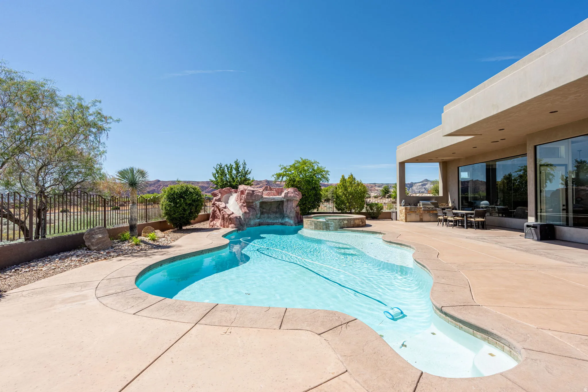Relaxing pool / spa with a patio and a fenced backyard