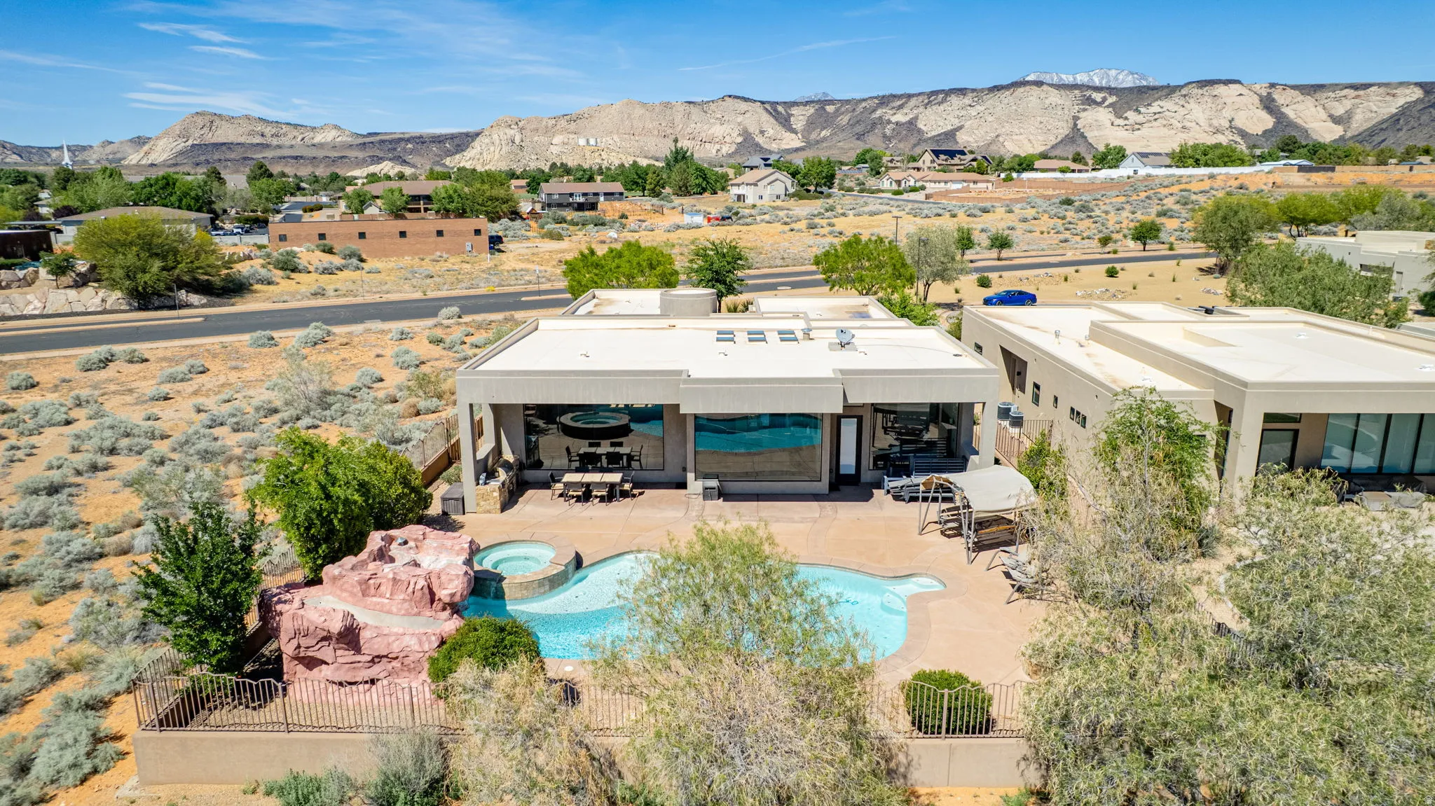 View of subject property with a mountain backdrop and a pool area