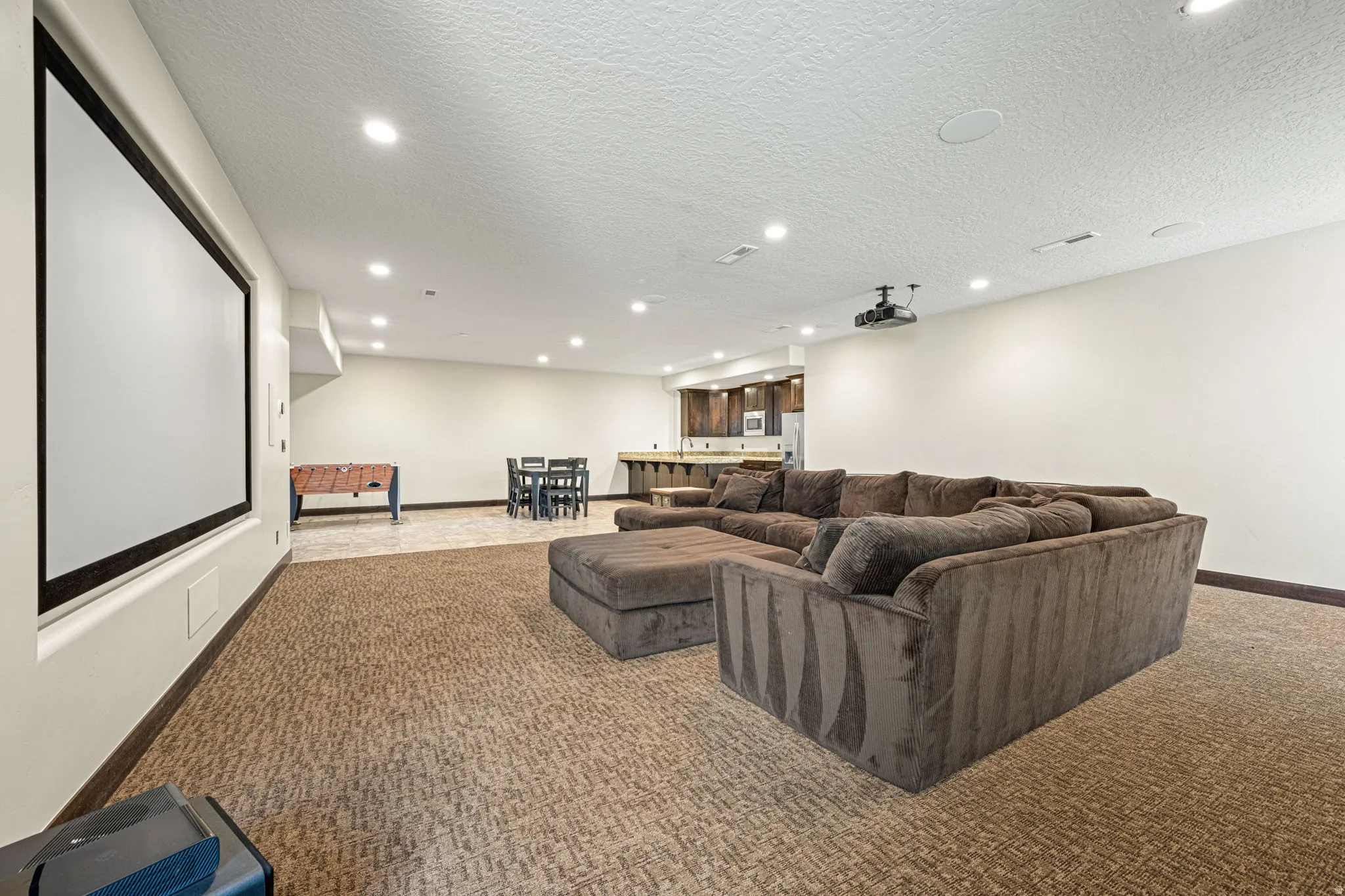 Cinema featuring recessed lighting, a textured ceiling, and carpet