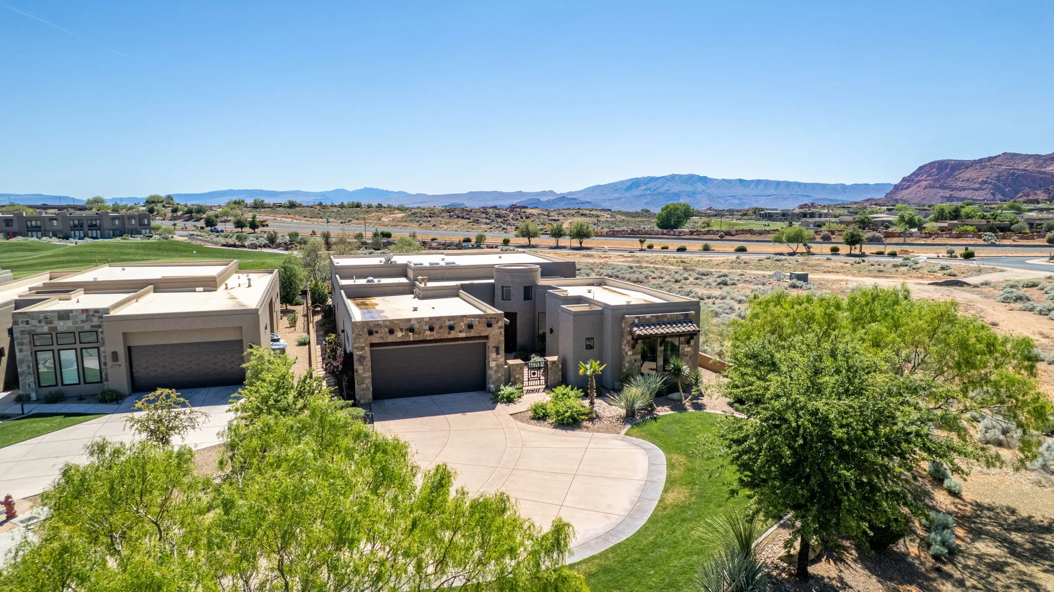 View of front of property featuring stucco siding, concrete driveway, an attached garage, and a mountain view