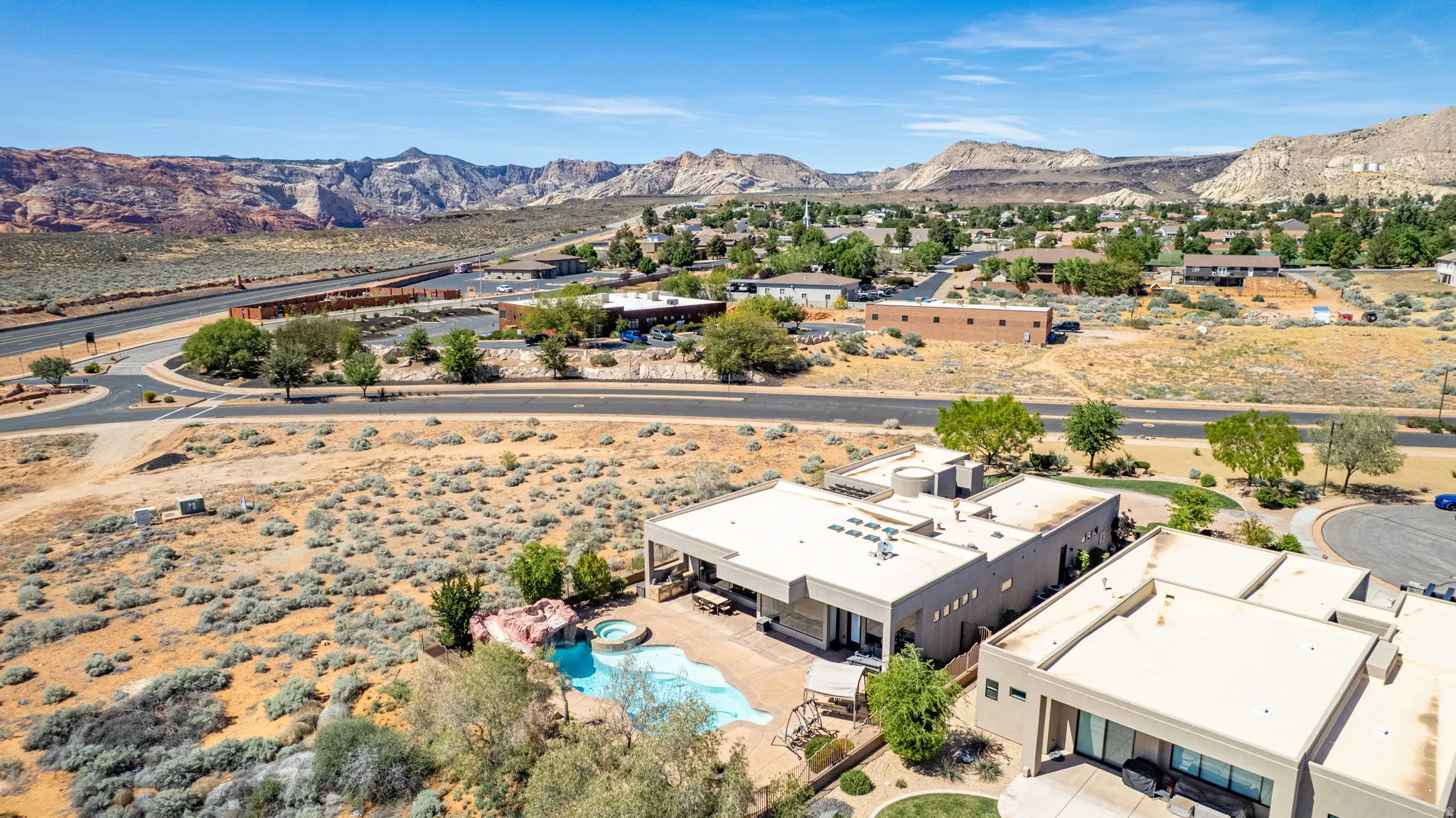 Drone / aerial view of a mountain backdrop and a pool area