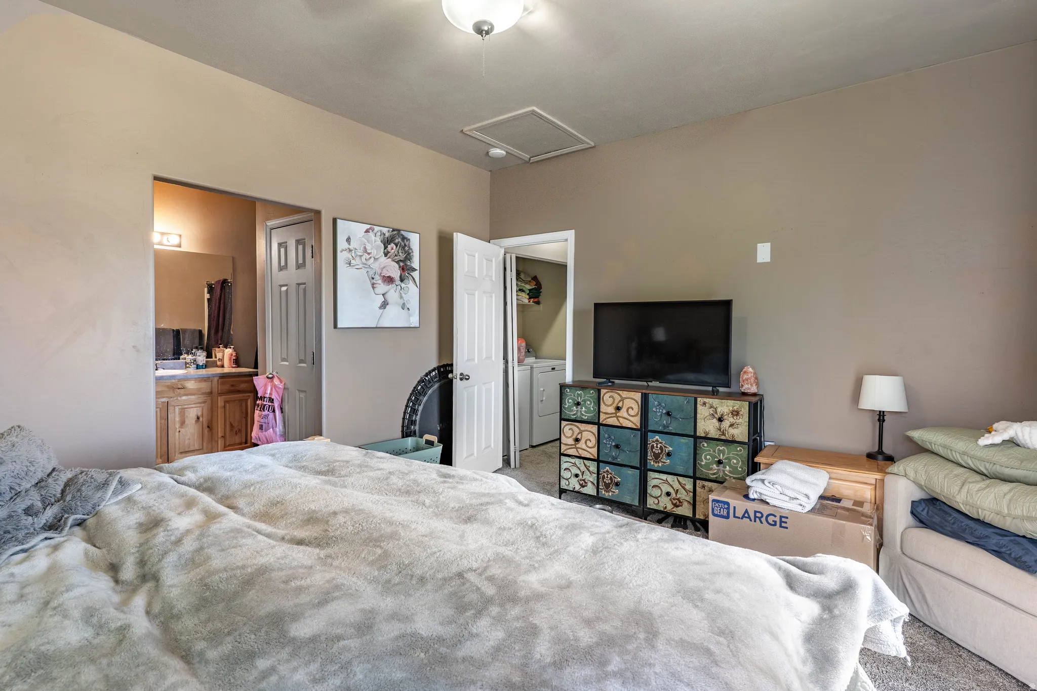 Carpeted bedroom with attic access and separate washer and dryer