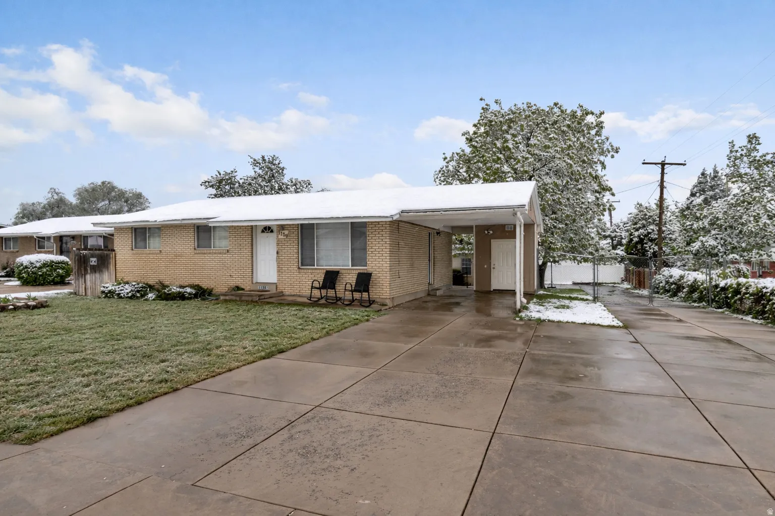 Single story home featuring driveway, a carport, and brick siding