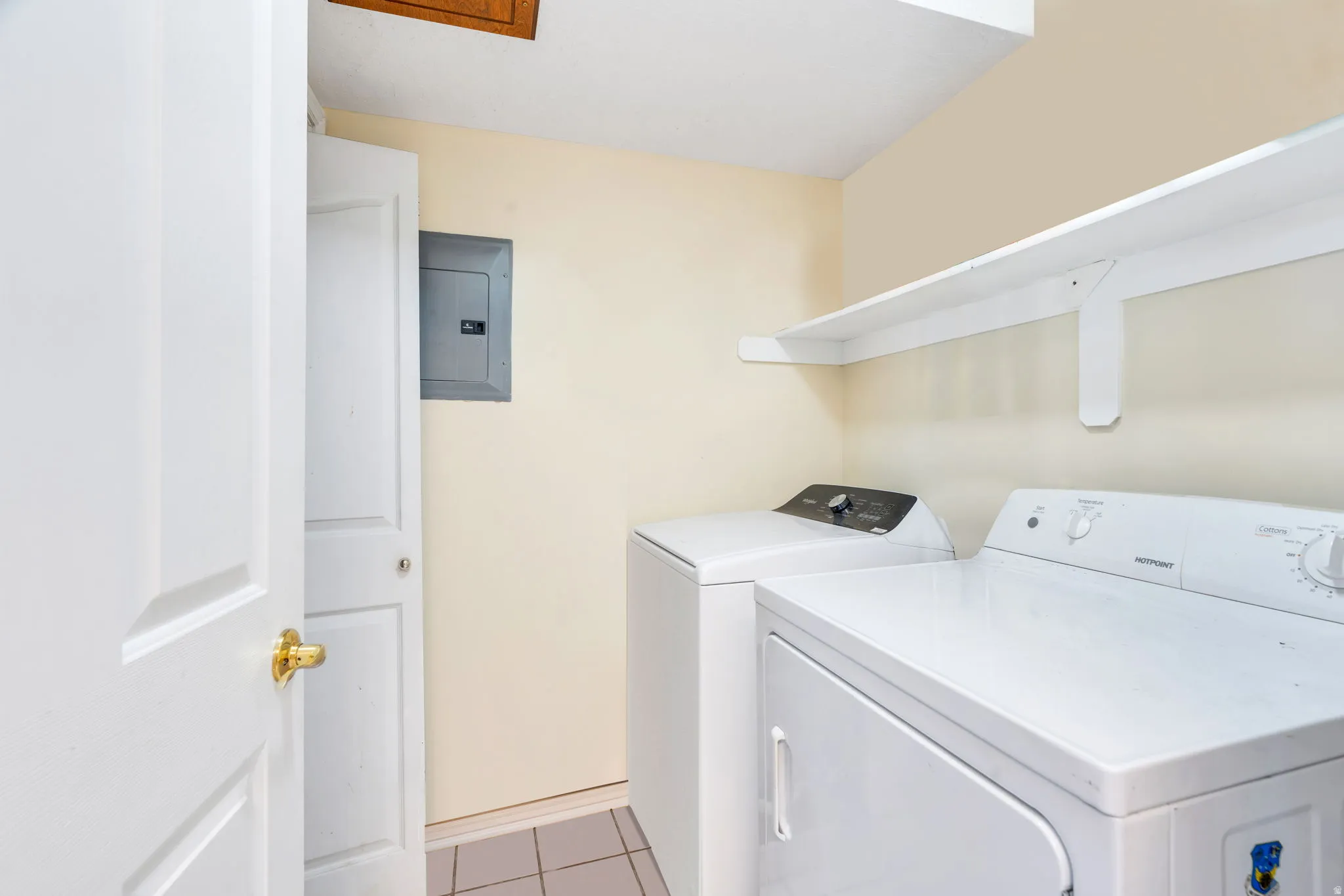Laundry room has room for separate washer/dryer and shelf storage