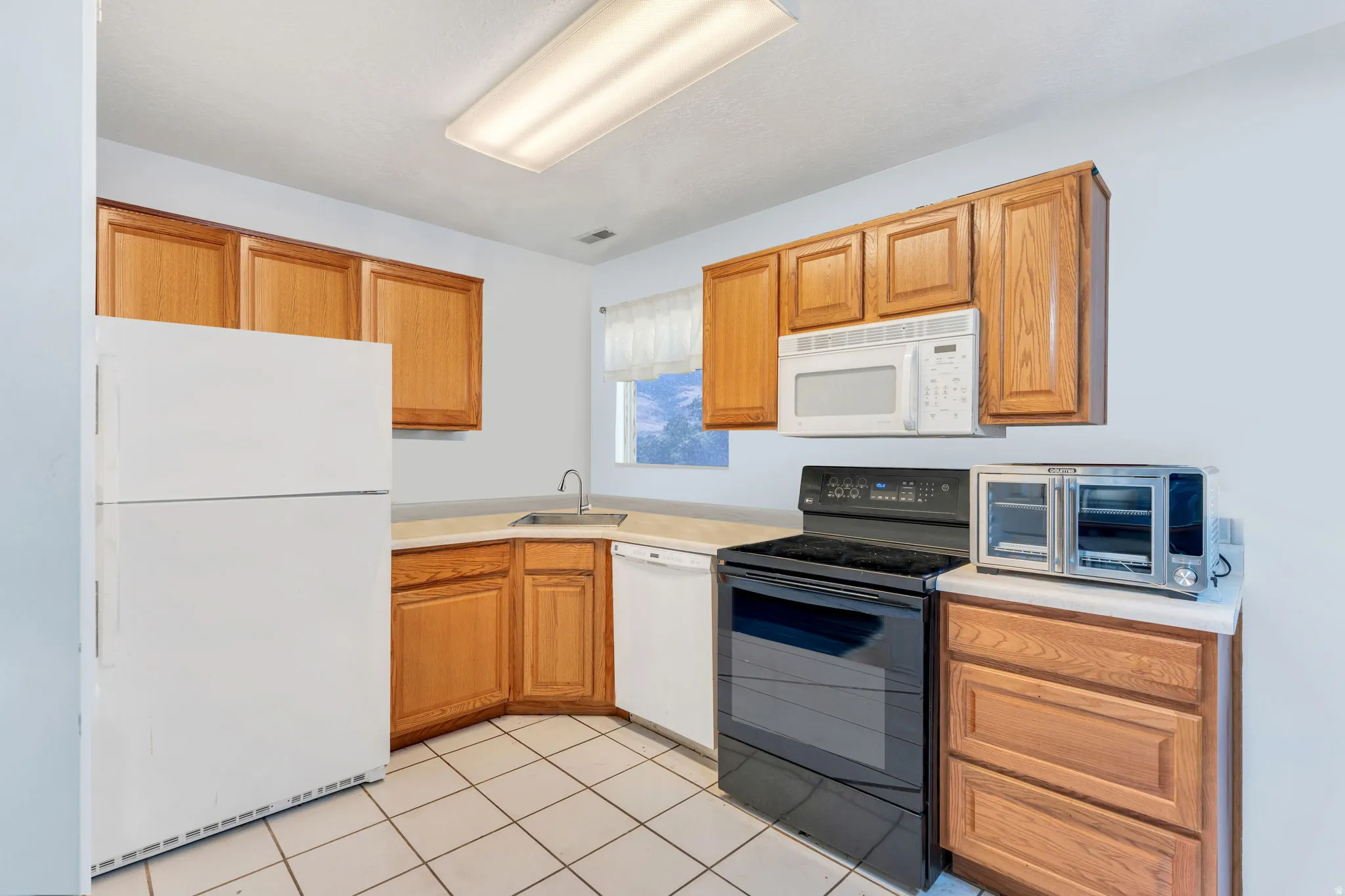 Kitchen with oak cabinets and tile floor
