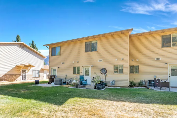 Rear view of property with a patio area and a yard