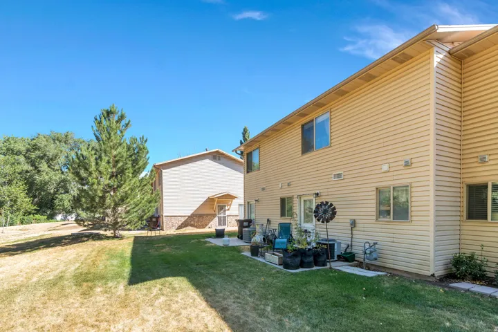 Rear view of house featuring a lawn and a patio area