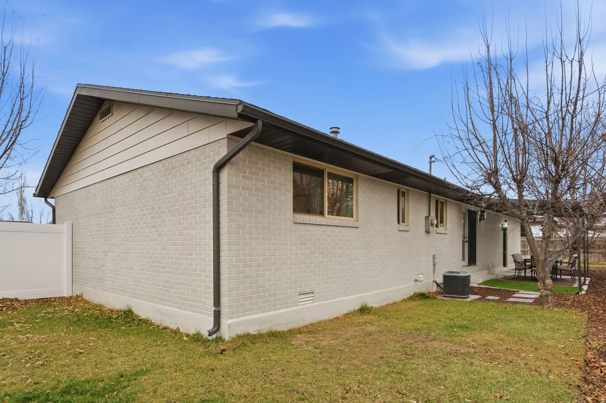 View of home's exterior with brick siding, crawl space, and a patio