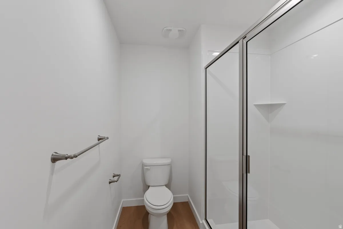 Bathroom featuring a shower stall and light wood-type flooring