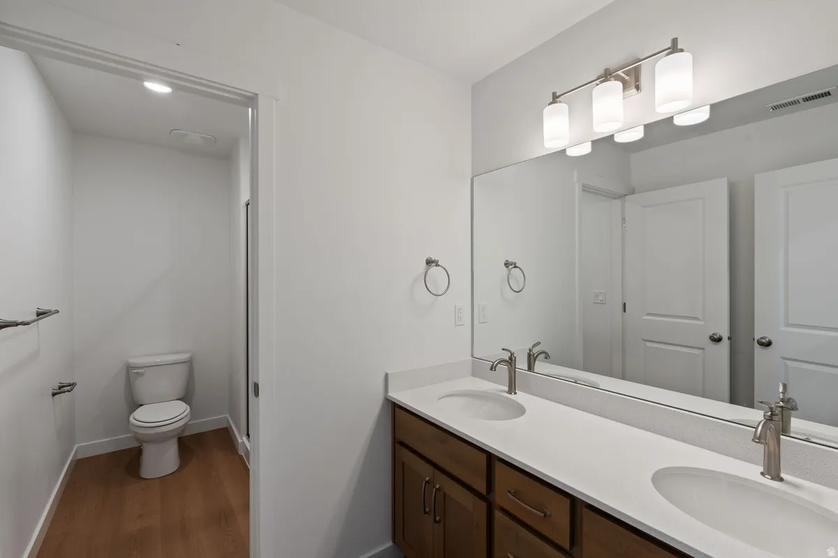 Bathroom with double vanity and dark wood finished floors