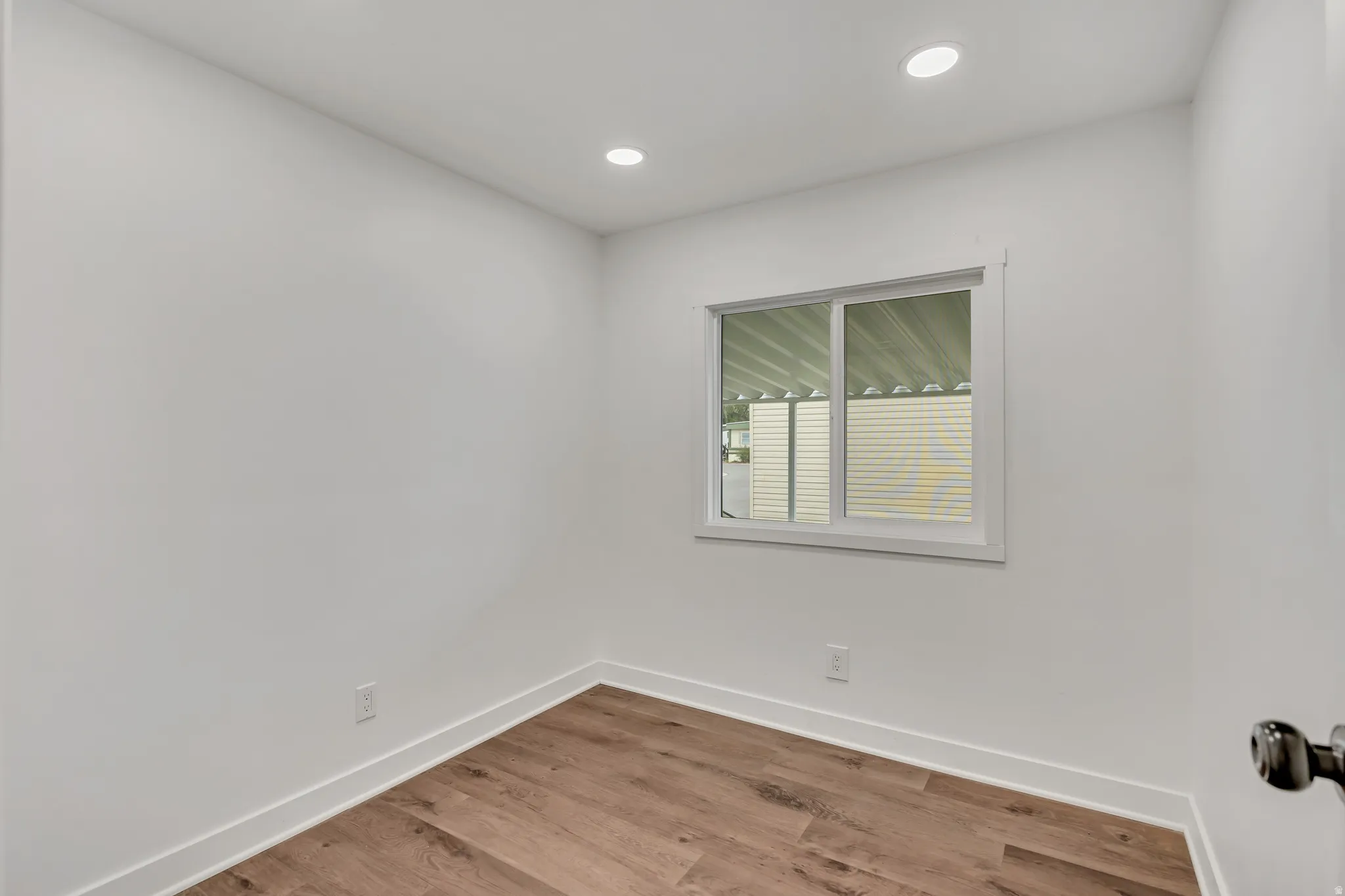 Empty room featuring light wood-type flooring and recessed lighting