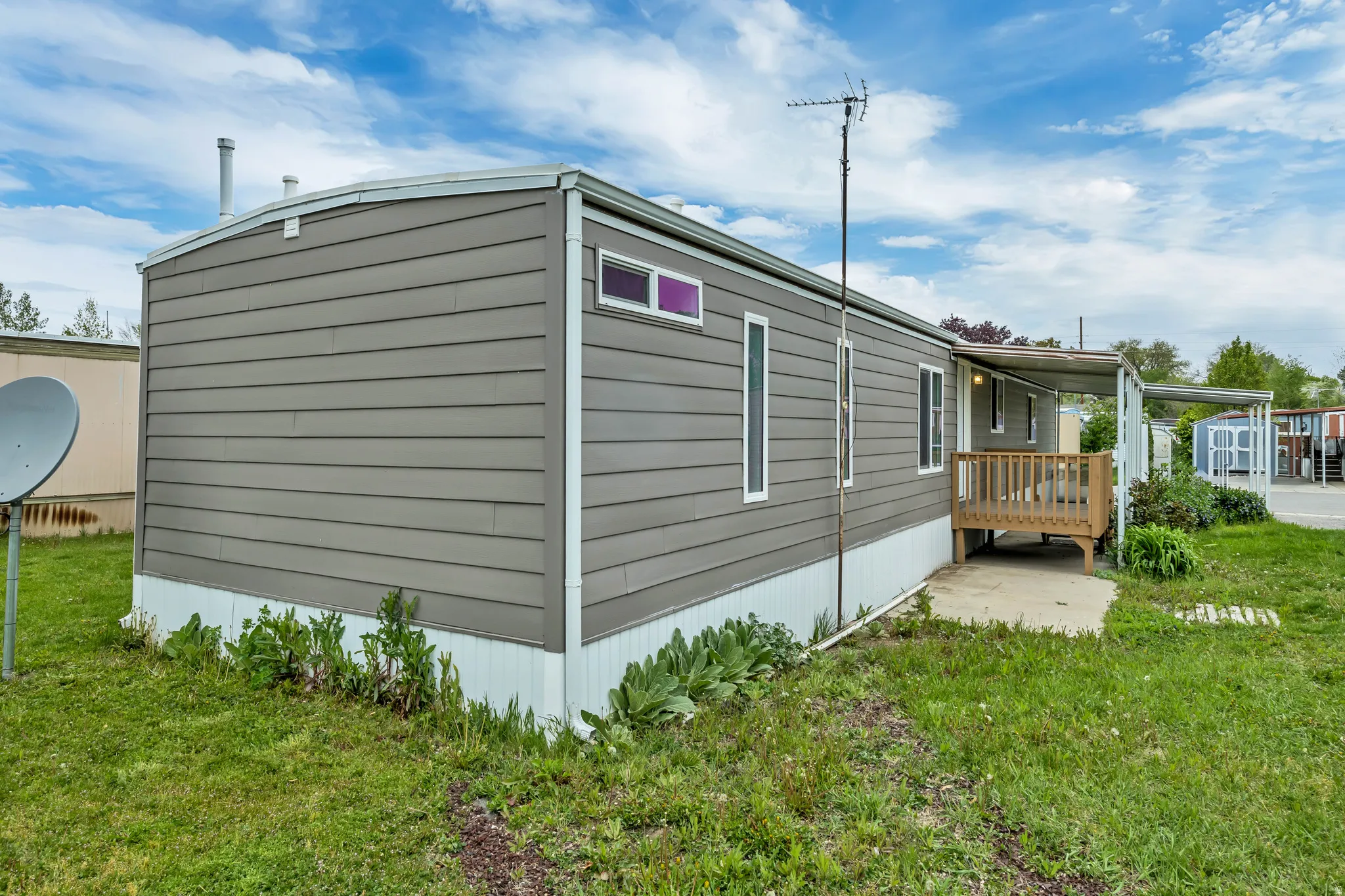 View of side of home featuring a lawn and an outdoor structure