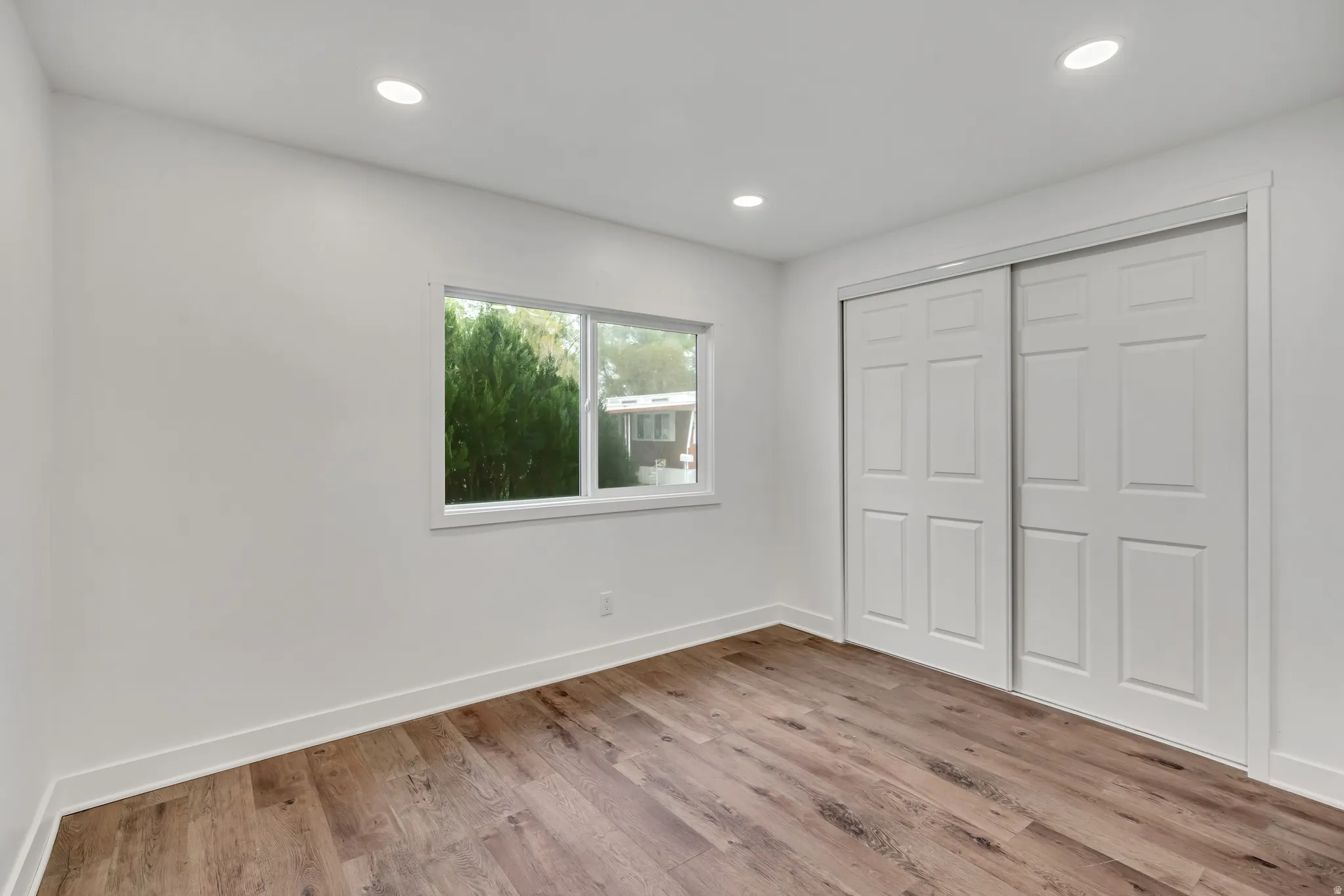 Unfurnished bedroom with a closet, light wood-style flooring, and recessed lighting