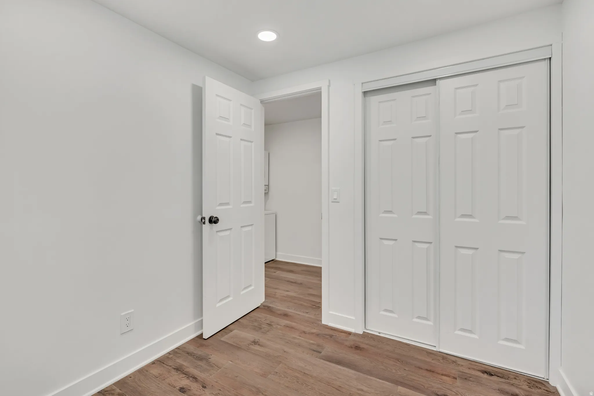 Unfurnished bedroom with light wood-style floors and a closet
