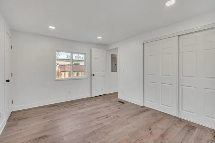 Unfurnished bedroom featuring a closet, recessed lighting, light wood finished floors, and electric panel