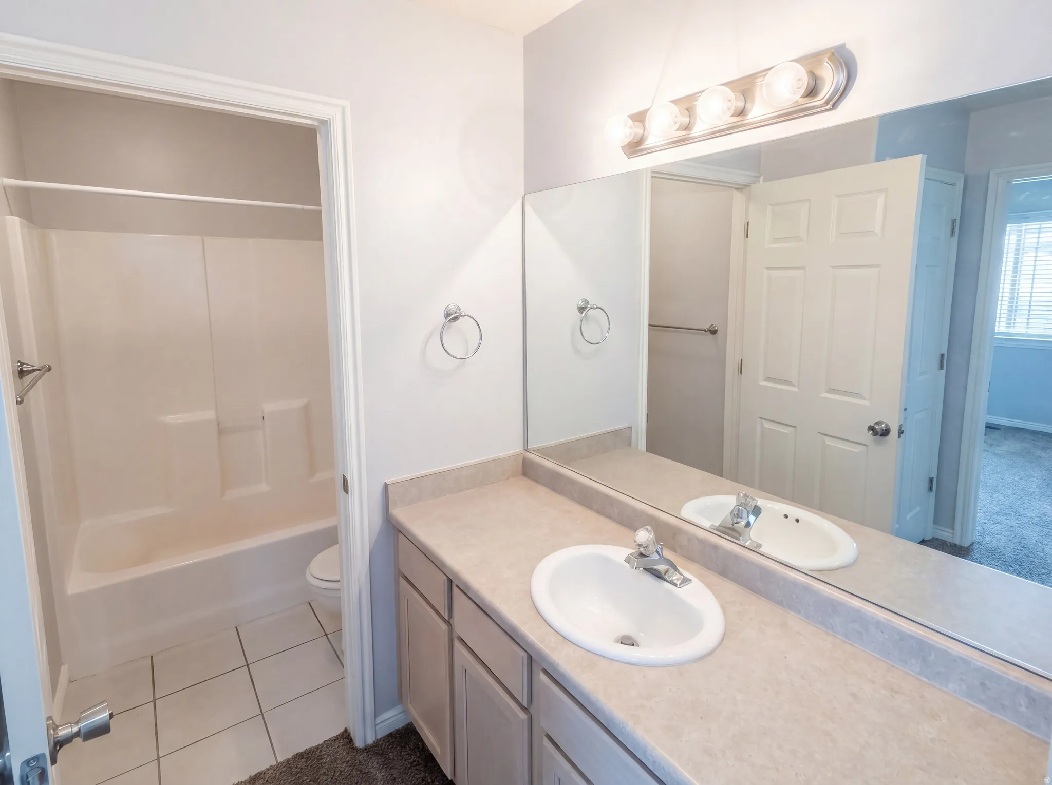 Bathroom with vanity, bathtub / shower combination, and dark tile patterned floors