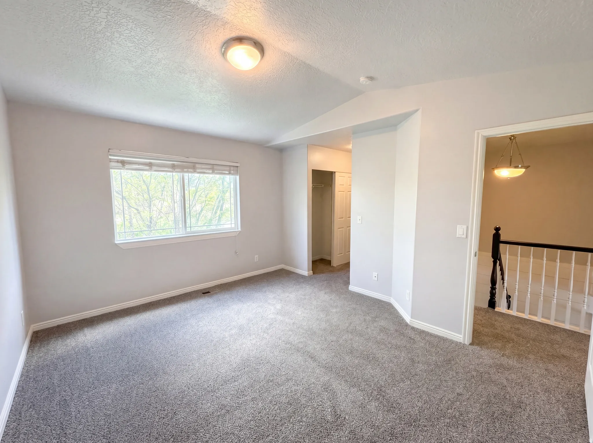 Carpeted spare room featuring baseboards