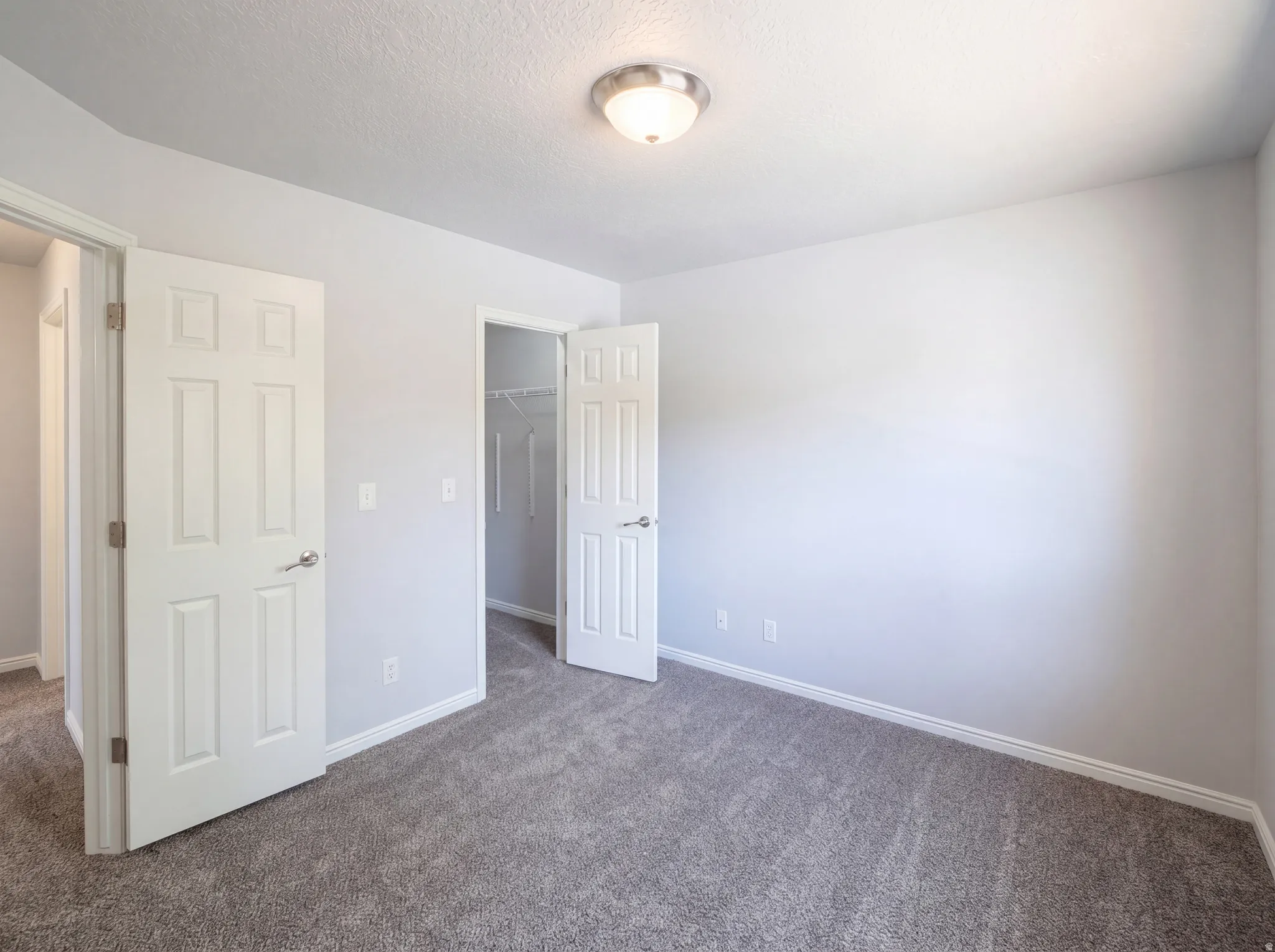 Unfurnished bedroom featuring a spacious closet and carpet floors